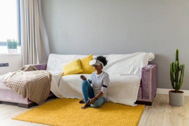 Afrikalı kadın izlerken video VR gözlükle evde uzaktan kumanda ile.