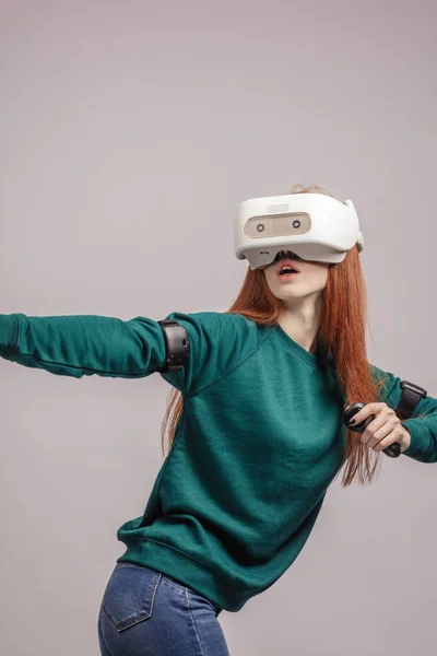 Впевнена руда жінка в гарнітурі віртуальної реальності, спрямована з лука — стокове фото