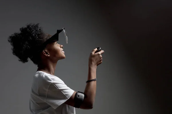 Mujer joven de raza mixta que usa auriculares VR de realidad virtual sobre fondo blanco . —  Fotos de Stock