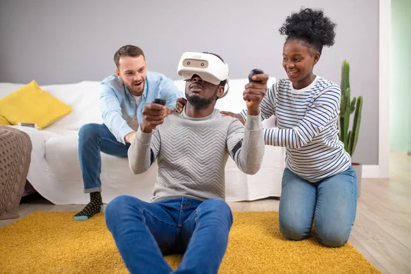 Multiracial group of friends having fun trying on 3D virtual reality goggles.