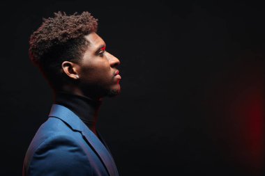 Nötr sakin yüz olan saç modeli ile Afrikalı yakışıklı genç adamın yan görünümü