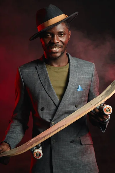 Joven empresario africano guapo con longboard en la oficina — Foto de Stock