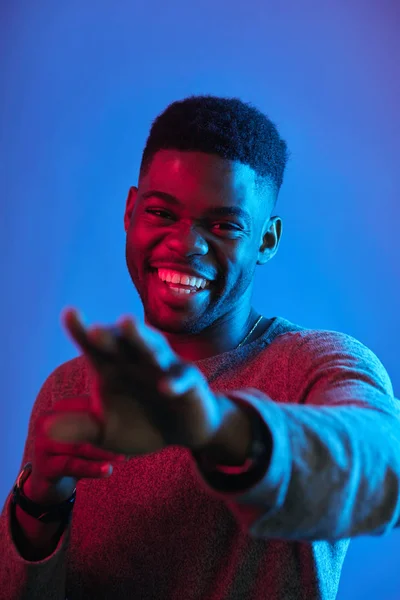 Lachen Afrikaanse man strekt zich uit hand suggereert ons om mee te doen tegen blauwe muur — Stockfoto