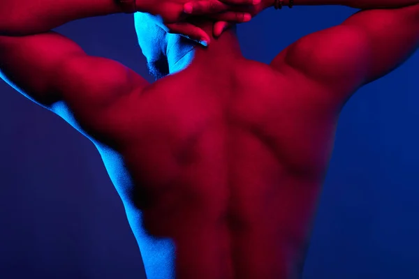 Visão traseira do atleta masculino africano com costas nuas posando contra a parede escura . — Fotografia de Stock
