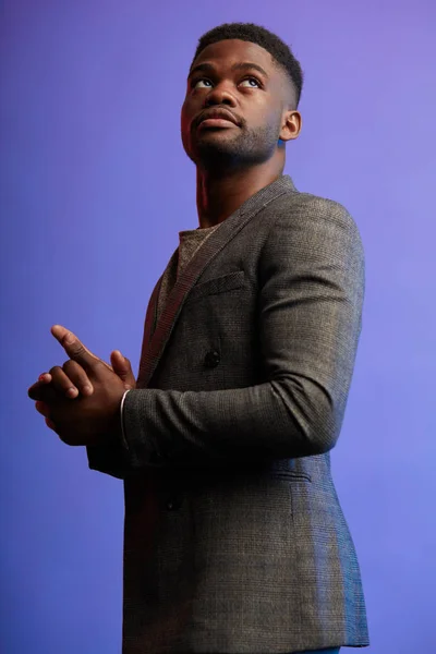 Porträt eines dunkelhäutigen Managers in eleganter Jacke, der auf violett posiert — Stockfoto