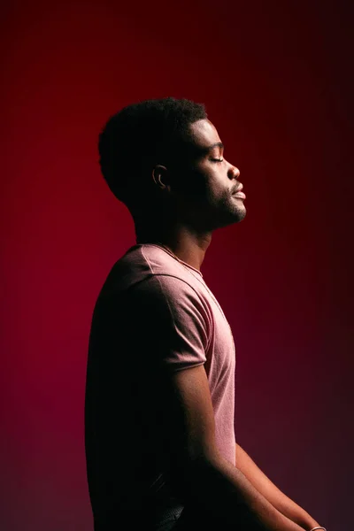 Handsome young dark-skinned male dressed in casual shirt posing in profile — Stock Photo, Image