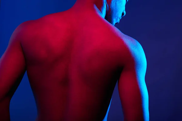 Close up of sports male muscular shirtless back isolated on dark background — Stock Photo, Image