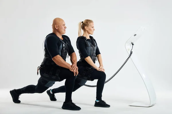 Fit man en vrouw stretching benen binnenshuis doen vooruit Lunge — Stockfoto