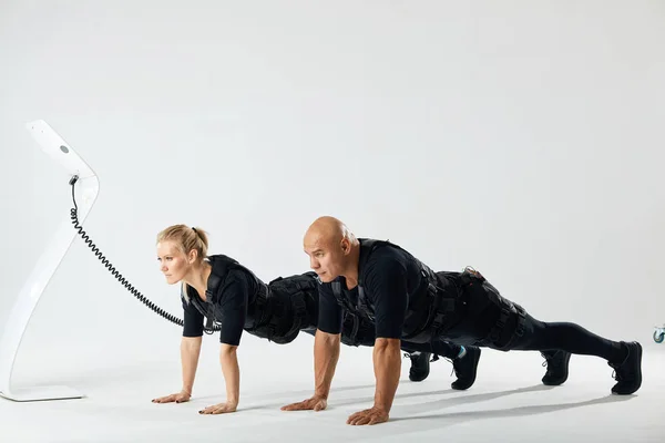 Jong sportief vrouw en man doen push-ups, — Stockfoto