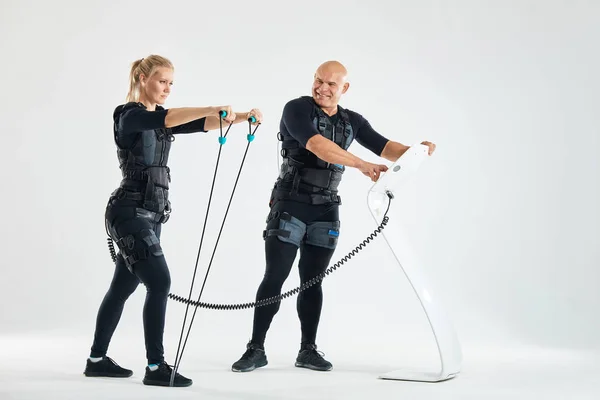 Man and woman in EMS suits training with expander — Stock Photo, Image