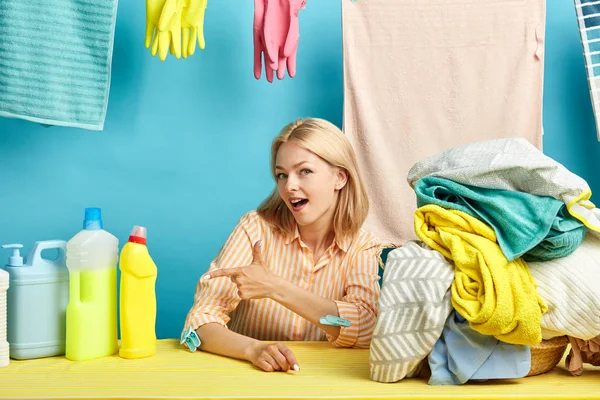 Feliz joven rubia mujer apuntando a lavavajillas botella líquida — Foto de Stock