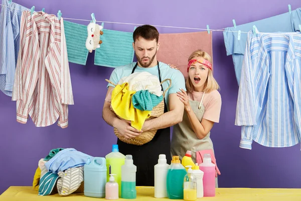 Jovem confuso e seu marido têm medo de roupas sujas — Fotografia de Stock