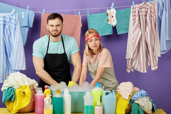 Triste colère froncement de sourcils couple lavage des vêtements par les mains — Photo