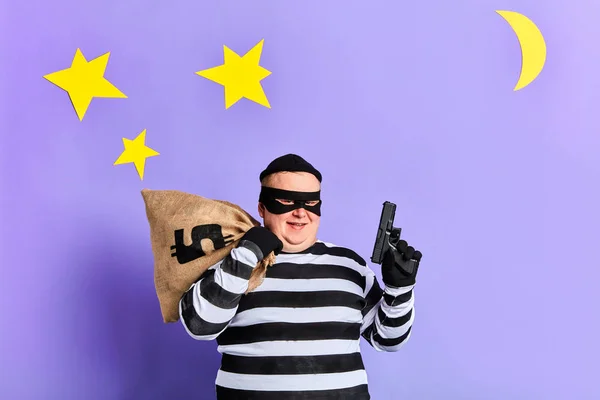 Frohgemut freut sich der dickliche Mann über gelungene Kränkungen. isolierter blauer Hintergrund. Studioaufnahme. — Stockbild Fröhlicher dicker Mann freut sich über gelungene Straftat — Stockfoto