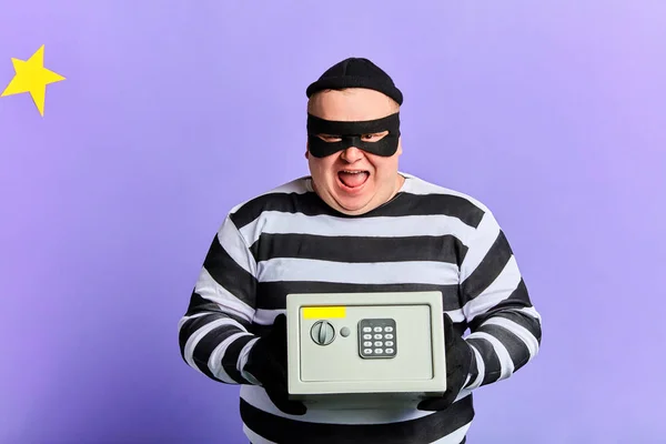 Maske ve çizgili giysiler güvenlik kutusu tutan mutlu neşeli heyecanlı hırsız — Stok fotoğraf