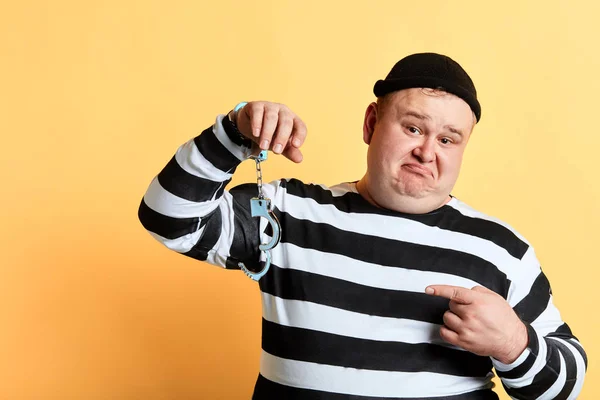 슬픈 불행한 뚱뚱한 남자는 자신의 손에 매달려 잠금 해제 수갑을 가리키는 — 스톡 사진