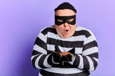 cunning thief in striped clothes with wide open mouth clipart