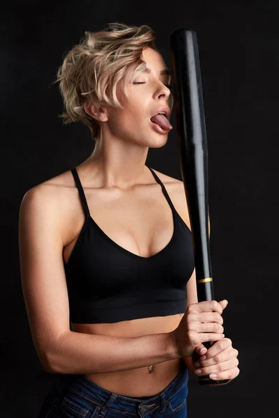 Mad carzy girl hsowing her tongue while holding a bat — Stock Photo, Image