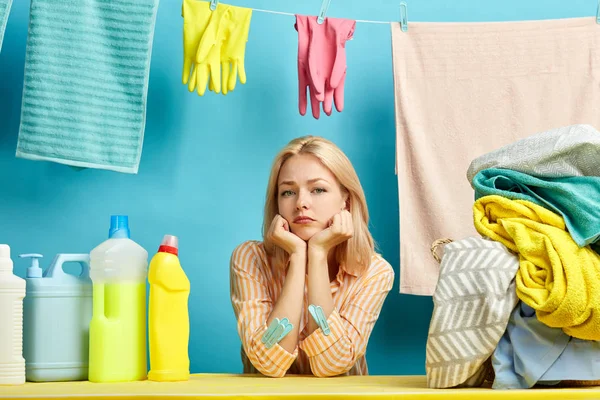 Fille sérieuse avec des poings sur la joue assis à la table, posant à la caméra — Photo