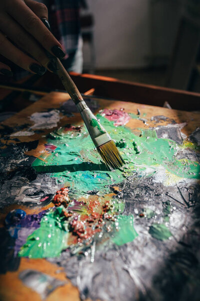 художник разбавляет краску. закрыть обрезанное фото
