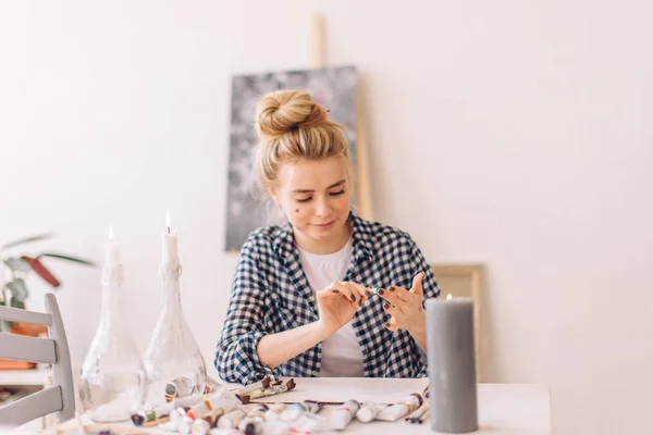 예술 스튜디오에서 테이블에 앉아 더러운 얼굴을 가진 여성 예술가 — 스톡 사진