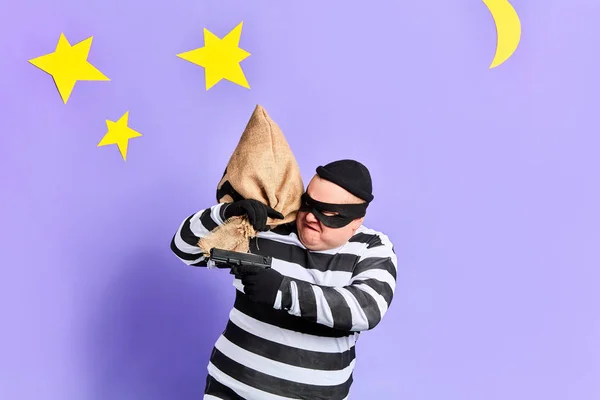 Wütender unglücklicher Mann in gestreifter Kleidung schießt auf Zeugen. isolierter blauer Hintergrund. Studioaufnahme. — Stockbild Wütender unglücklicher Mann schießt auf Zeugen — Stockfoto