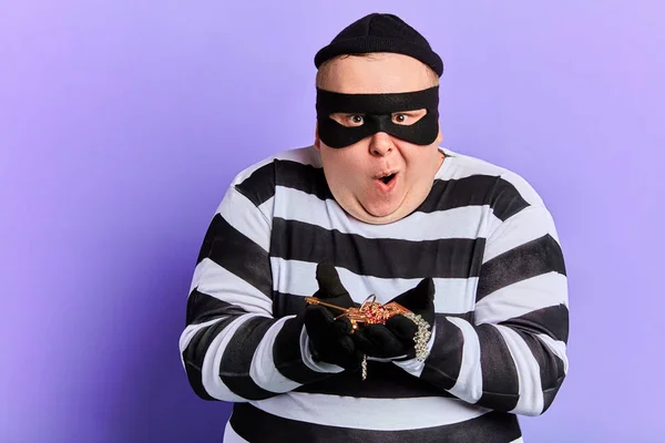 Cunning thief in striped clothes with wide open mouth — Stock Photo, Image