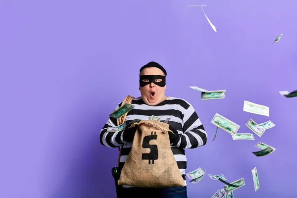 Plump thief is surprised at much money in the sack — Stock Photo, Image