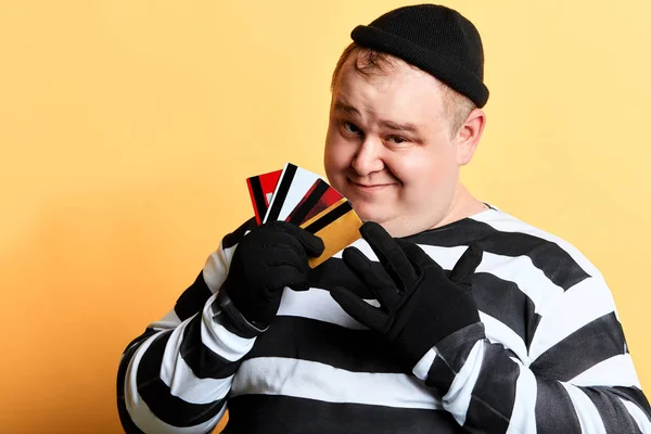 Hombre con ropa rasgada sosteniendo tarjeta de crédito robada, concepto de crimen —  Fotos de Stock
