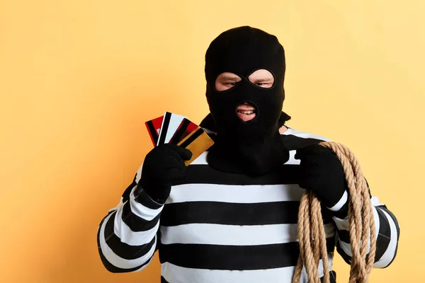 Gefangener mit Maske und Seil auf dem Rücken zeigt Kredit- und Einkaufskarten — Stockfoto