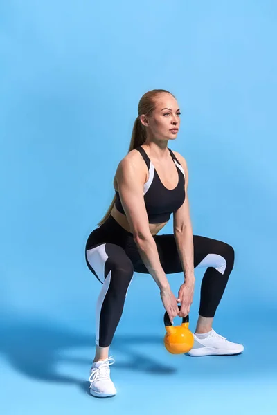 Junge starke Athletin macht Kniebeugen mit Gewicht — Stockfoto