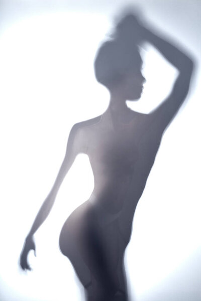Blurred image of young woman with raised arm looking aside. close up photo.