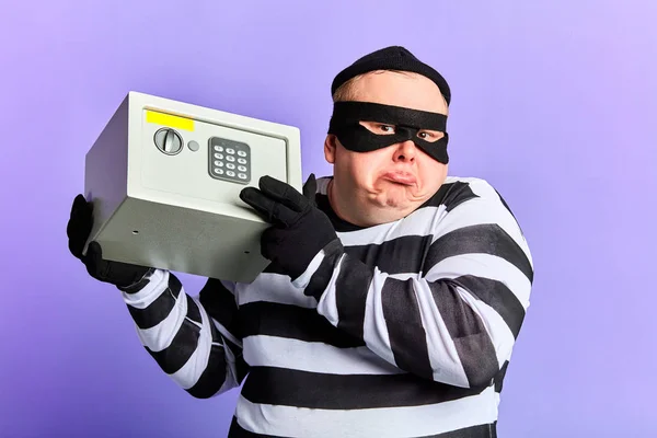 Χοντρός κλέφτης να κλείνει τον ώμο του κρατώντας ένα χρηματοκιβώτιο στα χέρια — Φωτογραφία Αρχείου