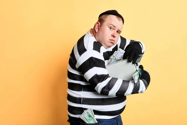 Prisionero codicioso abrazando una caja fuerte y mirando a la cámara — Foto de Stock