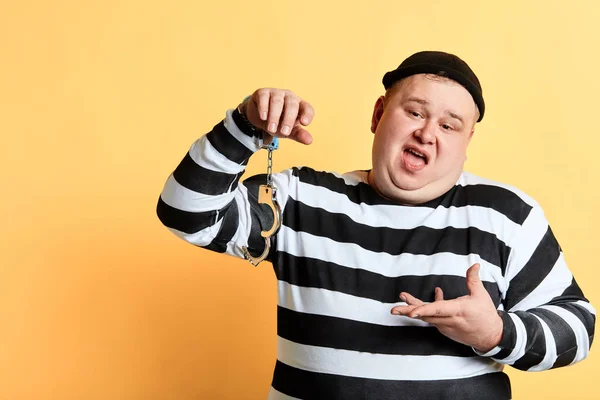 케이크 조각, 깨진 수갑을 보여주는 뚱뚱한 통통 범죄 — 스톡 사진