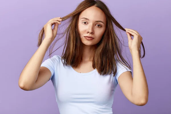 Menina atraente agradável tocando seu cabelo, tem problemas com seu penteado — Fotografia de Stock