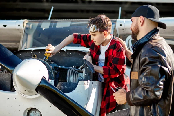 Letecký inženýr dává malému chlapíkovi způsoby, jak provádět mechaniku motoru letadla — Stock fotografie