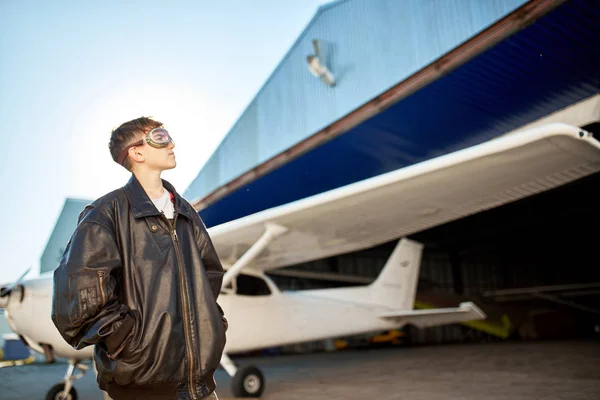 Junge schaut nachdenklich, denkt an ersten Flug, trägt große Pilotenjacke — Stockfoto