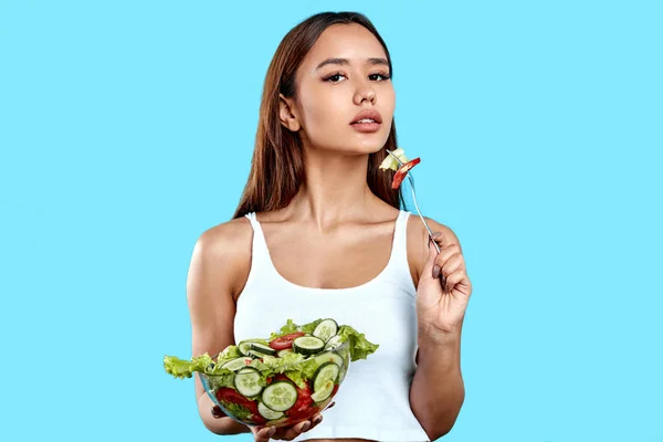 Засмагла спортсменка їсть салат з виделкою — стокове фото