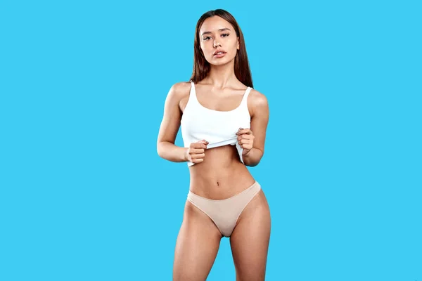 Atractiva modelo sexy caliente levantando su parte superior, mostrando su cuerpo perfecto —  Fotos de Stock