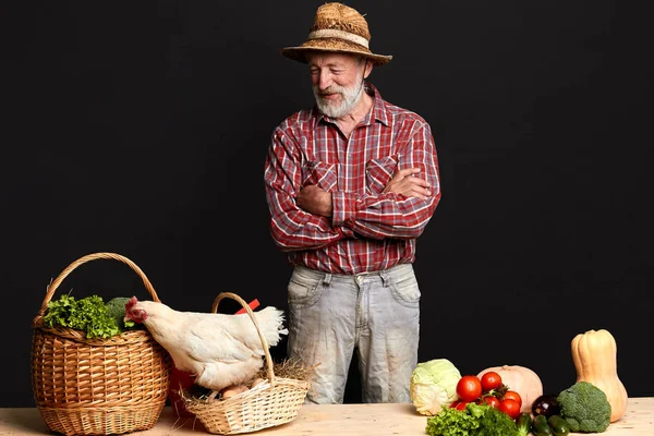 Granjero mayor de pie con las manos cruzadas, mirando a la gallina tratando de huir — Foto de Stock