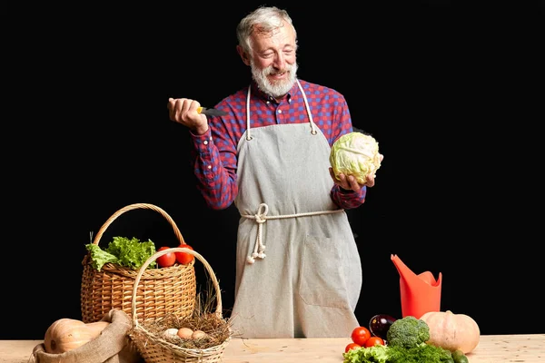 Alegre granjero senior divirtiéndose durante la cocina almuerzo saludable para sus amigos — Foto de Stock