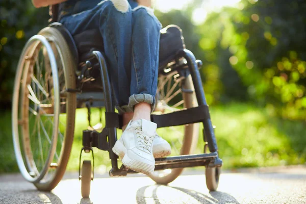 Jeune fille handicapée dans l'ensemble assis avec les jambes croisées sur le fauteuil roulant — Photo