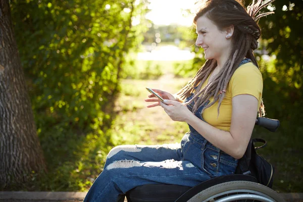 Lächelndes behindertes Mädchen, das Spaß mit seinem Smartphone hat — Stockfoto