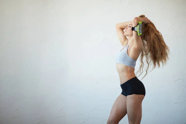 Mujer delgada y en forma peinándose. chica haciendo una cola de caballo antes del entrenamiento —  Fotos de Stock