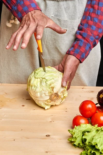 Close up on male hands cutting with knife fresh raw cabbage