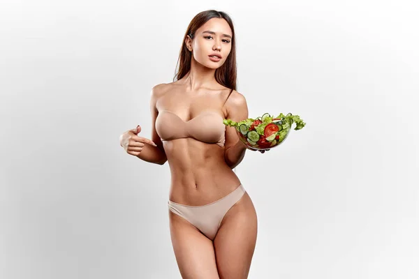 Impresionante desnuda sexy chica sosteniendo ensalada y apuntando a ella —  Fotos de Stock