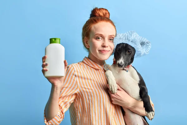 Ginger stylish girl in striped shirt holding effective shampoo from fleas — Stock Photo, Image
