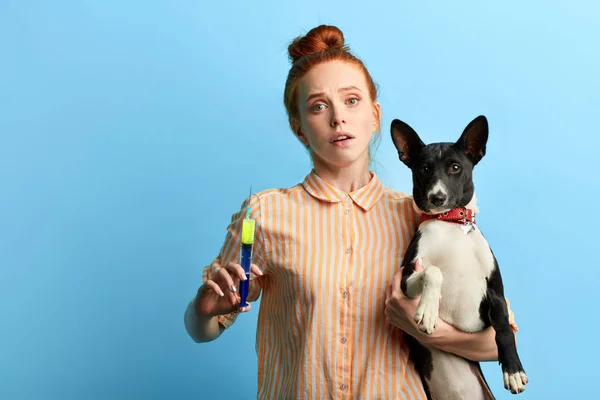 puzzled sad depressed woman in striped shirt holding her pet