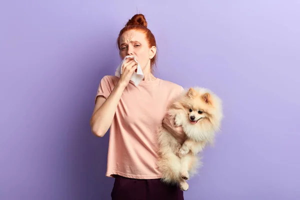 Menina doente com coque de cabelo soprando o nariz — Fotografia de Stock